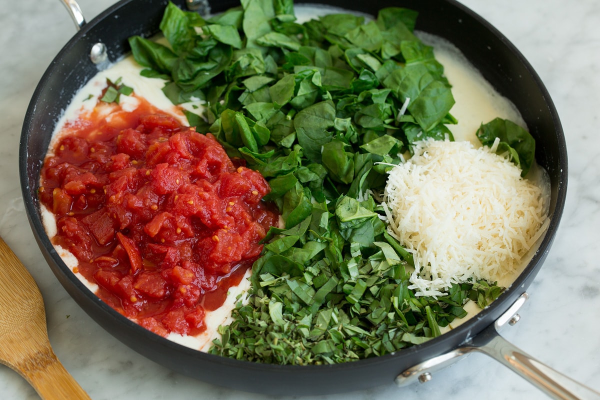 Creamy Spinach Tomato Tortellini Spinach, tomatoes, fresh herbs and parmesan added to milk mixture in skillet.