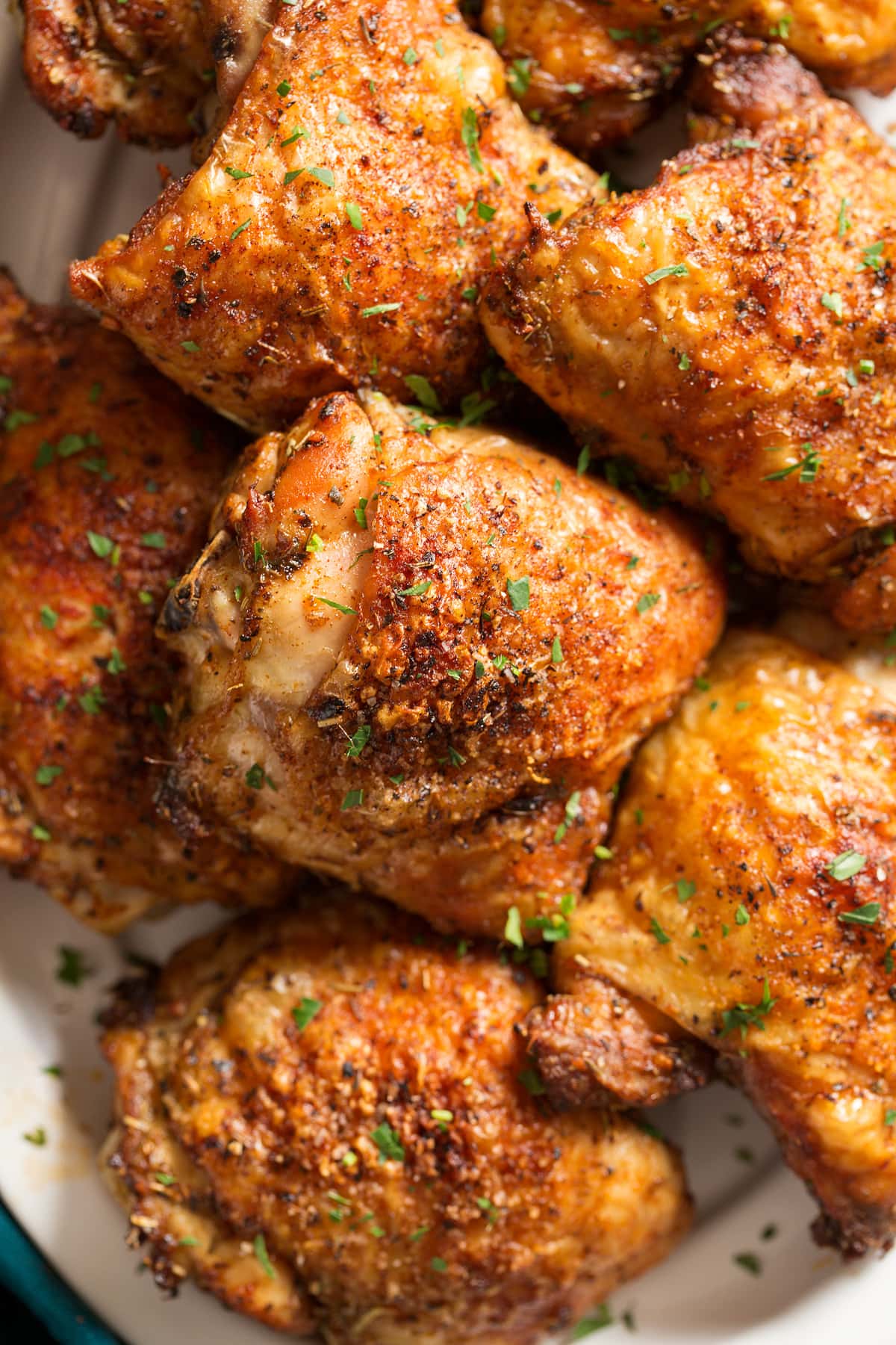 Baked Chicken Thighs Baked chicken thighs stacked together on a platter.