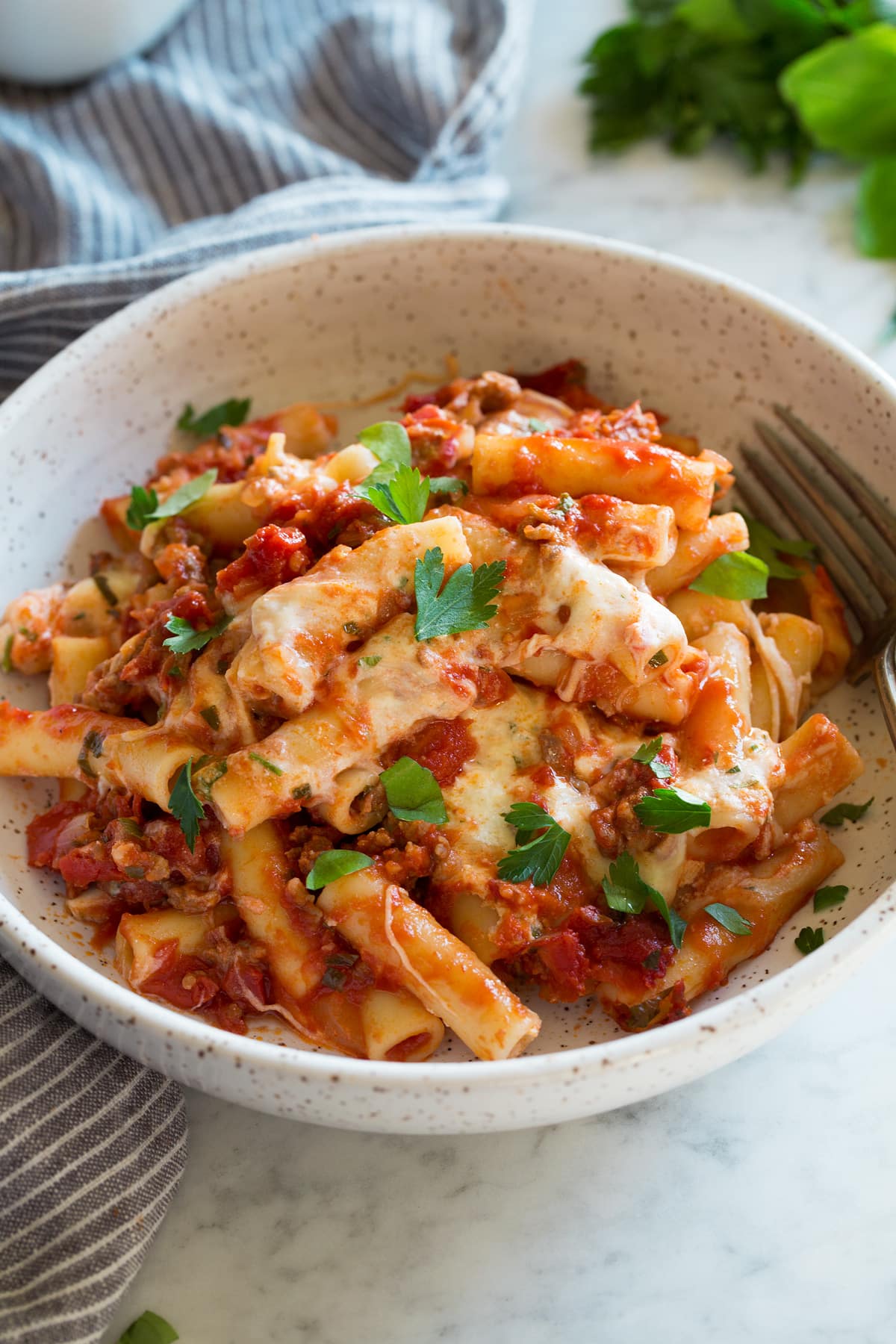 Baked Ziti Single serving of baked ziti in a pasta bowl, garnished with fresh parsley on top.