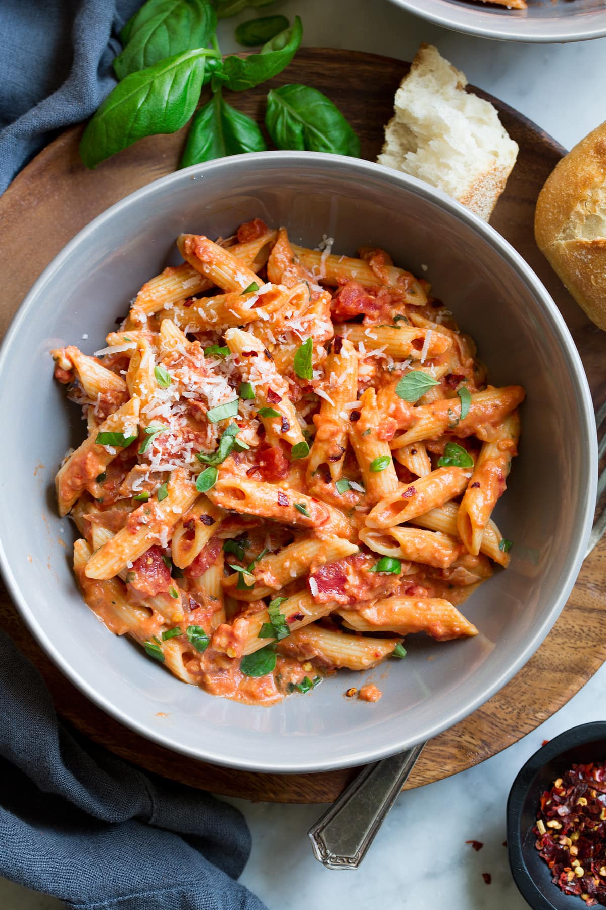 Penne all Vodka Pasta bowl filled with penne tossed with vodka sauce and garnished with fresh basil and oregano. Served with a side of fresh Italian bread.