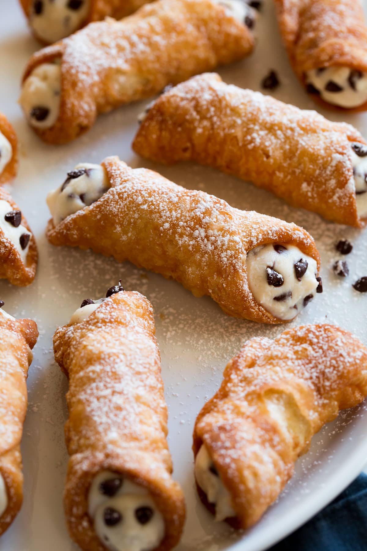 Cannoli Recipe (Shells and Filling) Cannoli on a serving platter, showing one close up.
