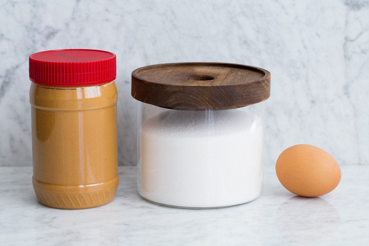 3 Ingredient Peanut Butter Cookies Image of ingredients including creamy peanut butter, granulated sugar in a glass jar and 1 egg.