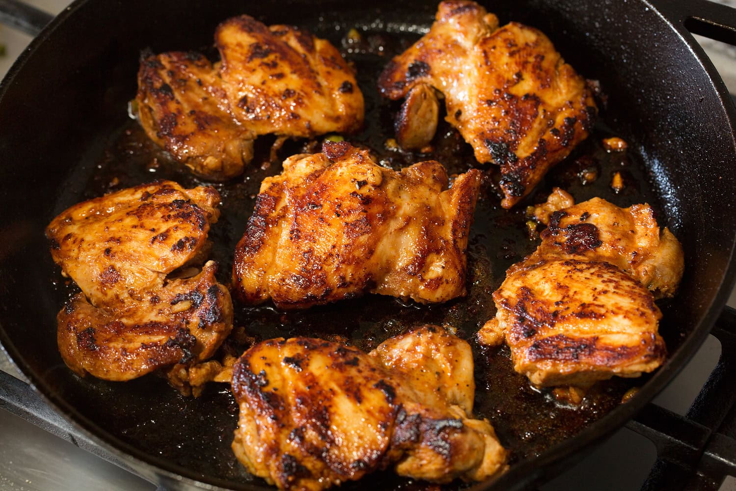 Chicken Fajitas Chicken thighs seared in a cast iron skillet.