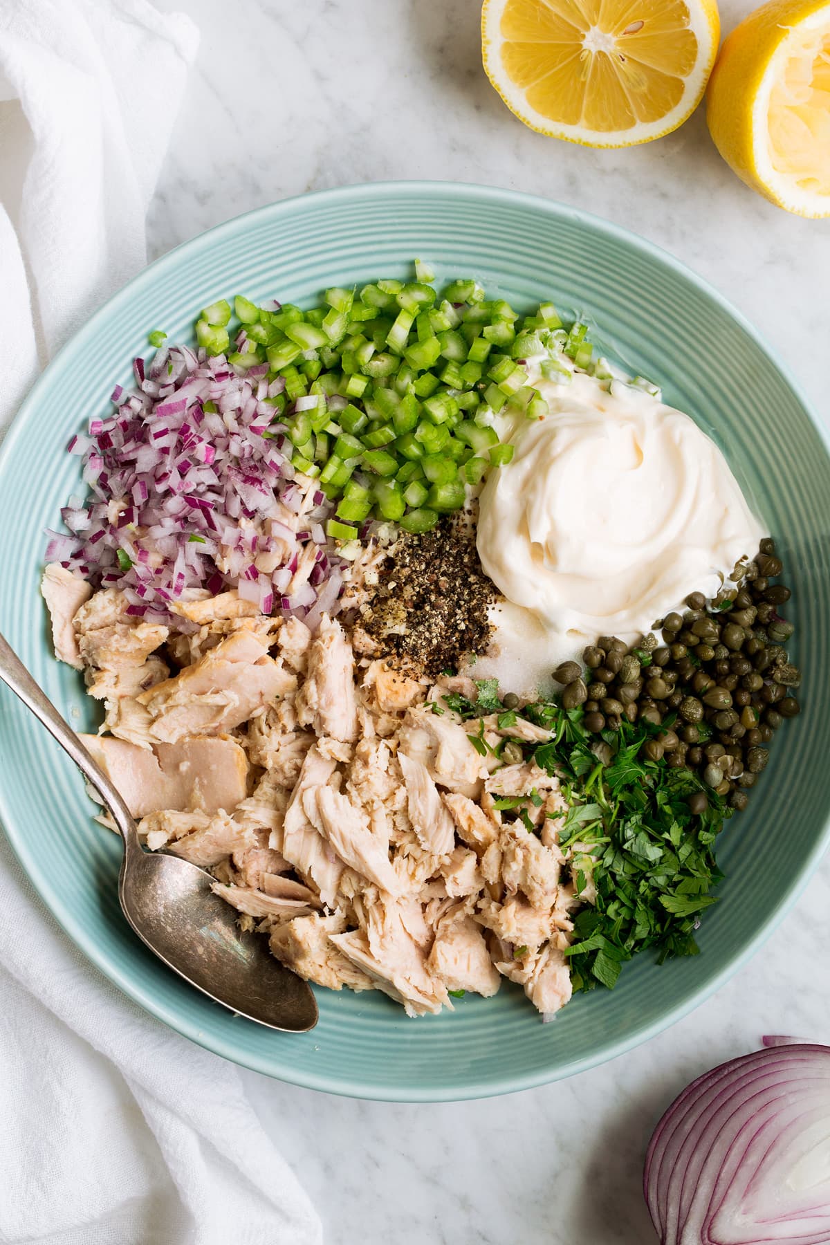Tuna Salad Image of tuna, parsley, red onion, celery, mayonnaise, lemon juice, capers, salt and pepper in a mixing bowl.