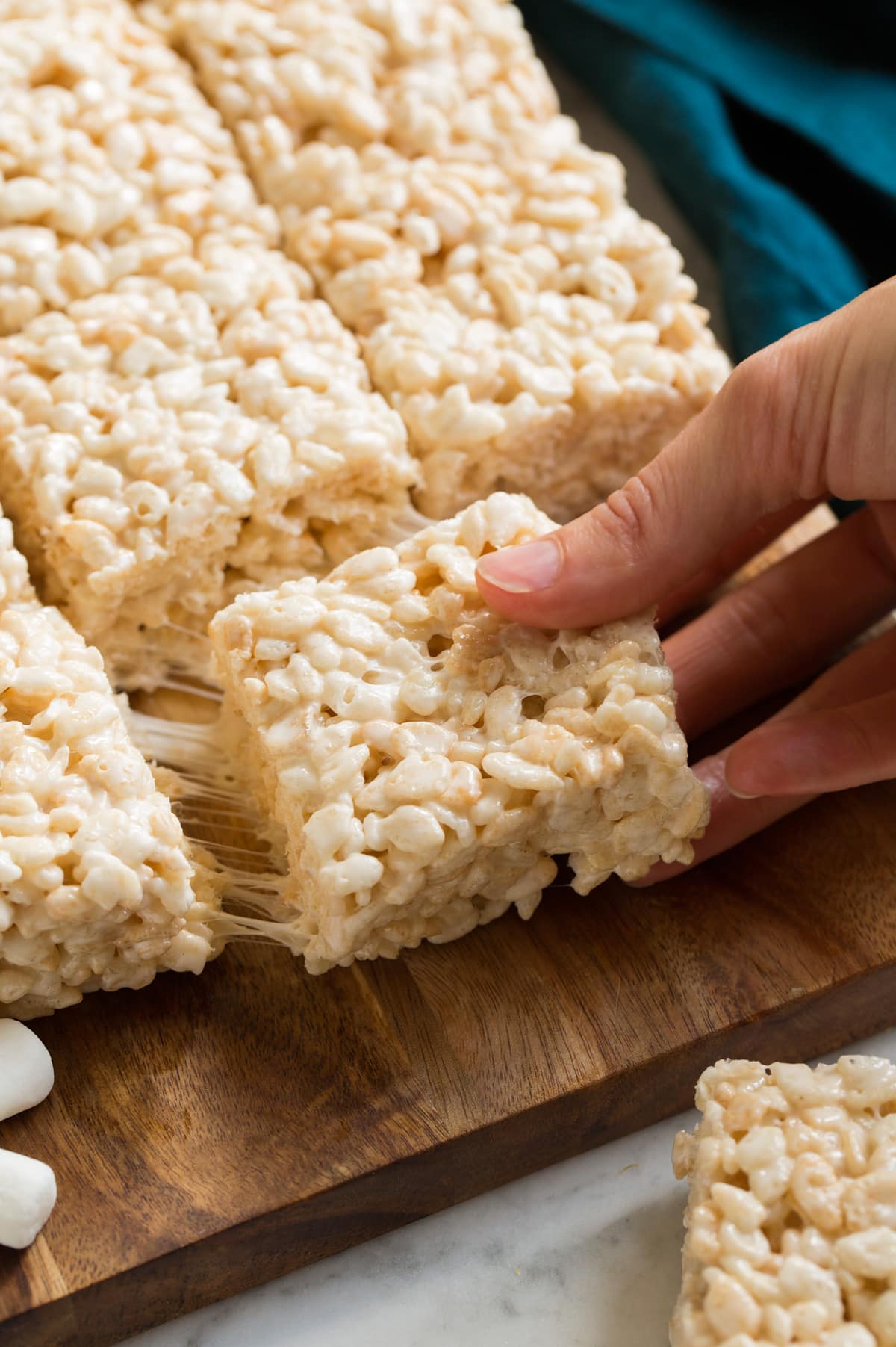 Rice Krispie Treats Hand removing rice krispie treat from batch.