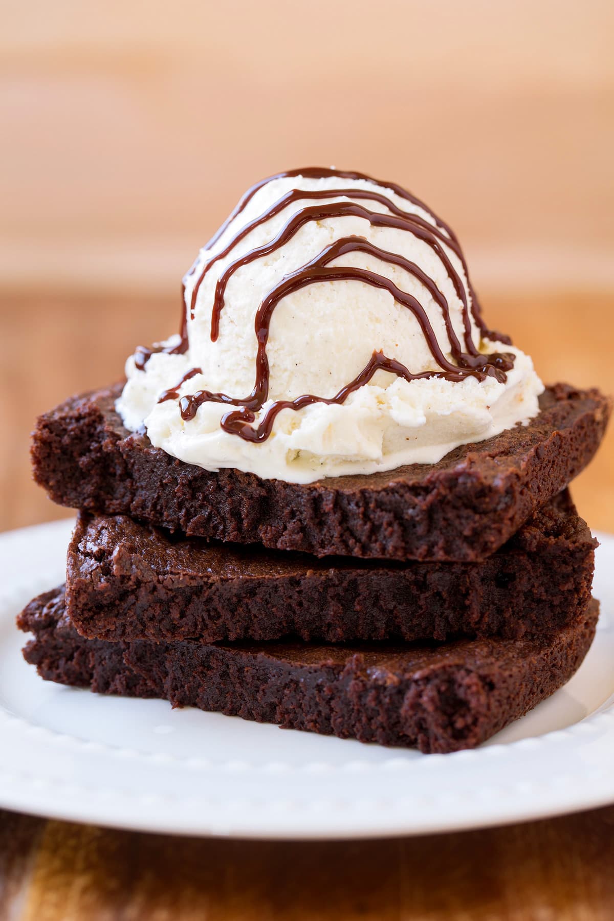 Small Batch Brownies Stack of 3 brownies with ice cream and hot fudge sauce on top.