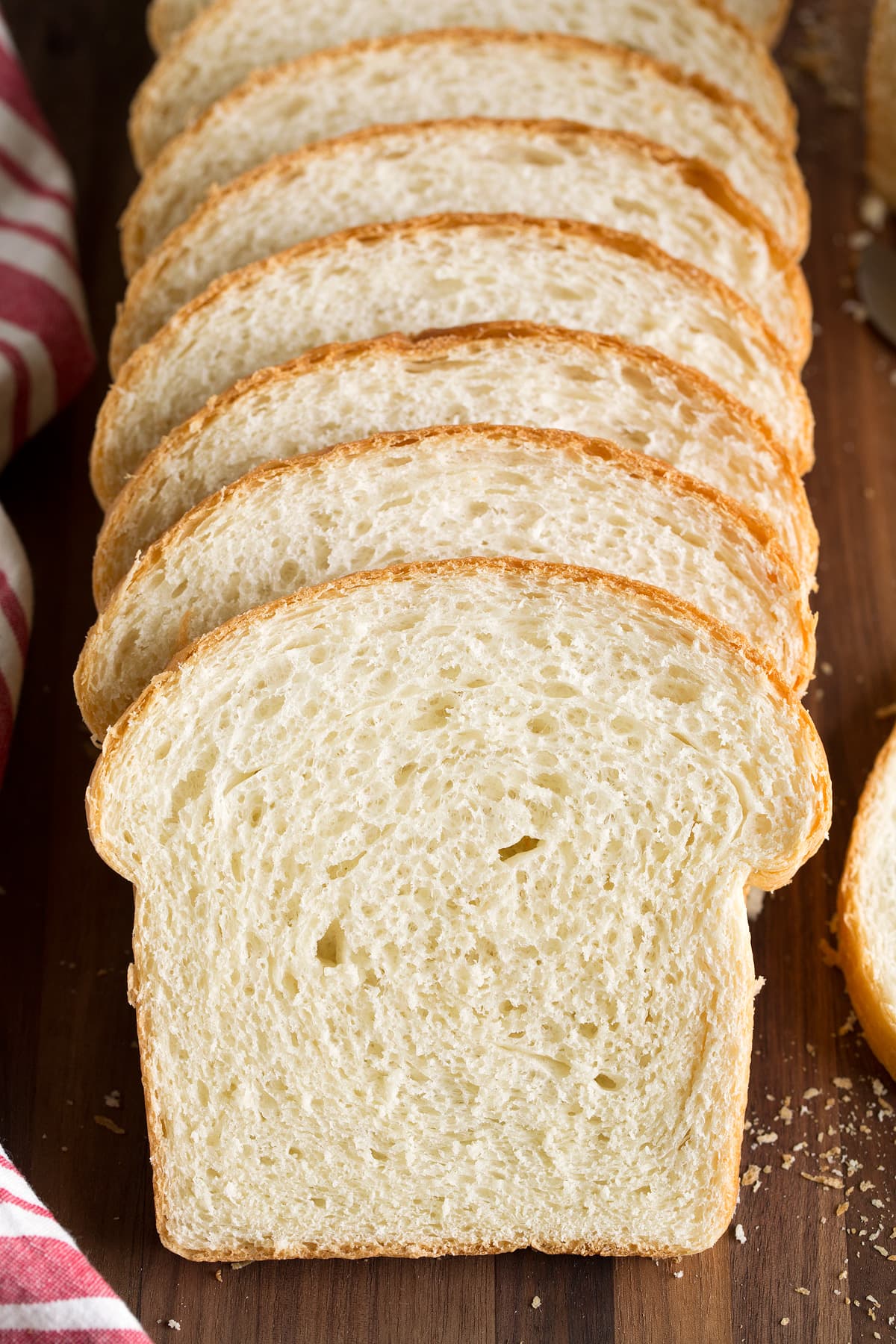 Homemade White Bread Recipe Close up image showing a row of homemade white bread slices on a cutting board.