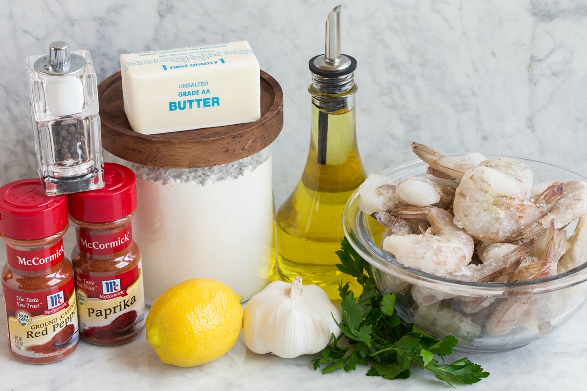 Hawaiian Garlic Shrimp Image of ingredients used to make Hawaiian garlic shrimp. Includes raw shrimp, olive oil, parsley, garlic, lemon, flour, butter, paprika, cayenne pepper, salt and pepper.