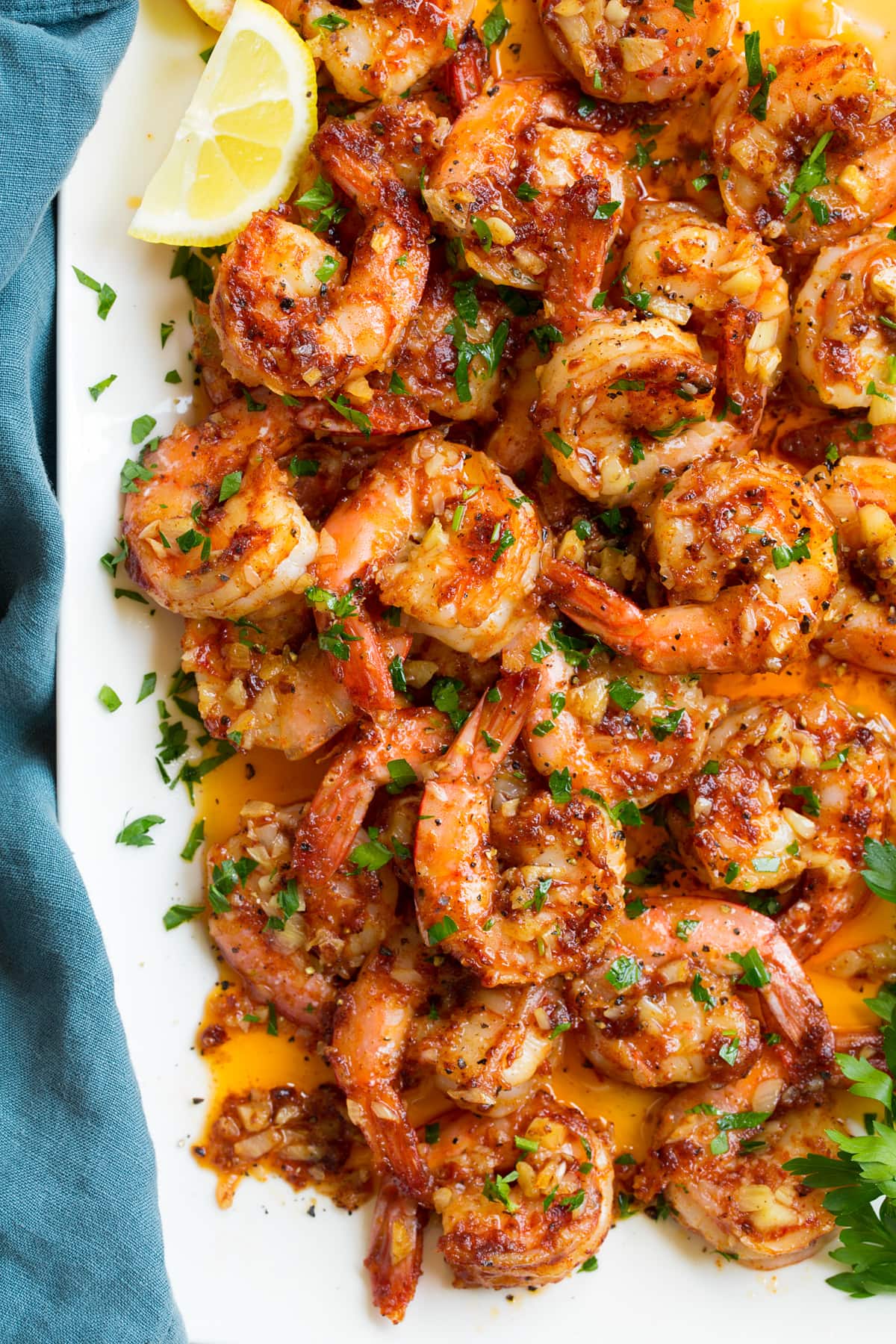 Hawaiian Garlic Shrimp Close up overhead image of Hawaiian garlic shrimp on a white platter with the butter sauce.
