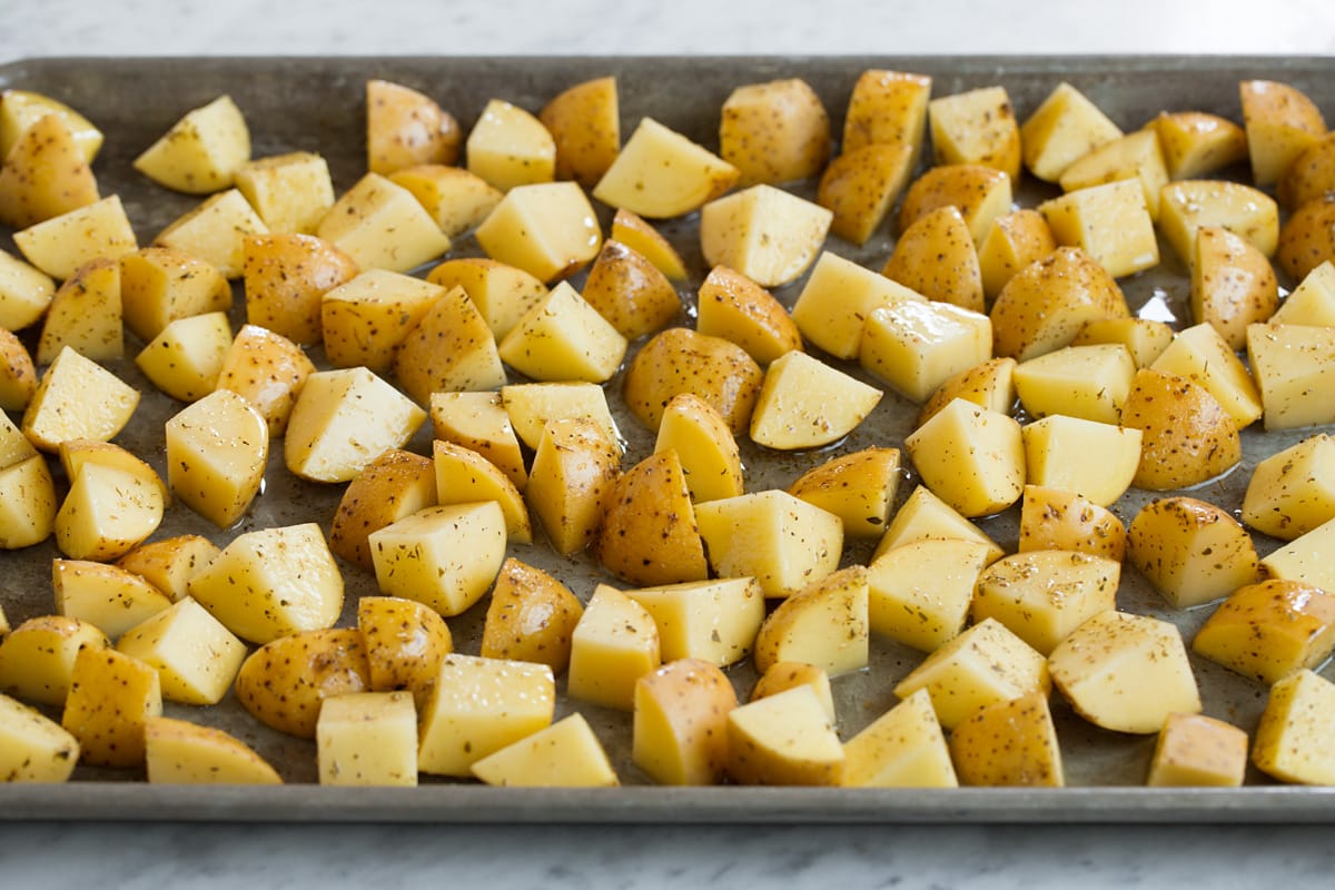 Lemon Roasted Potatoes Seasoned yukon gold potatoes spread out on a baking sheet.