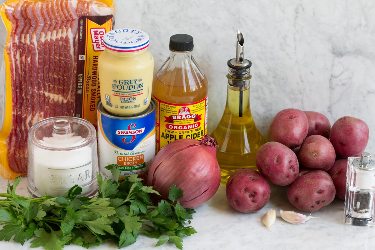 German Potato Salad Image of ingredients that are used to make German potato salad. Includes red potatoes, olive oil, bacon, vinegar, onion, chicken broth, garlic, dijon mustard, parsley, and bacon.