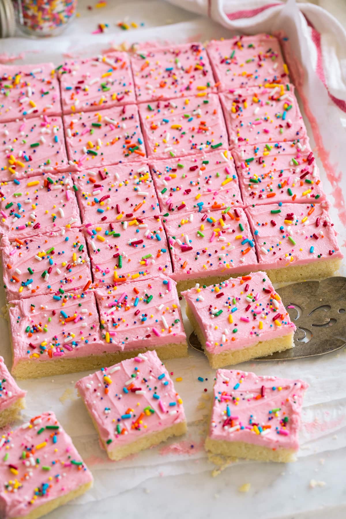 Sugar Cookie Bars Sugar cookie bars shown cut and laying on parchment paper.