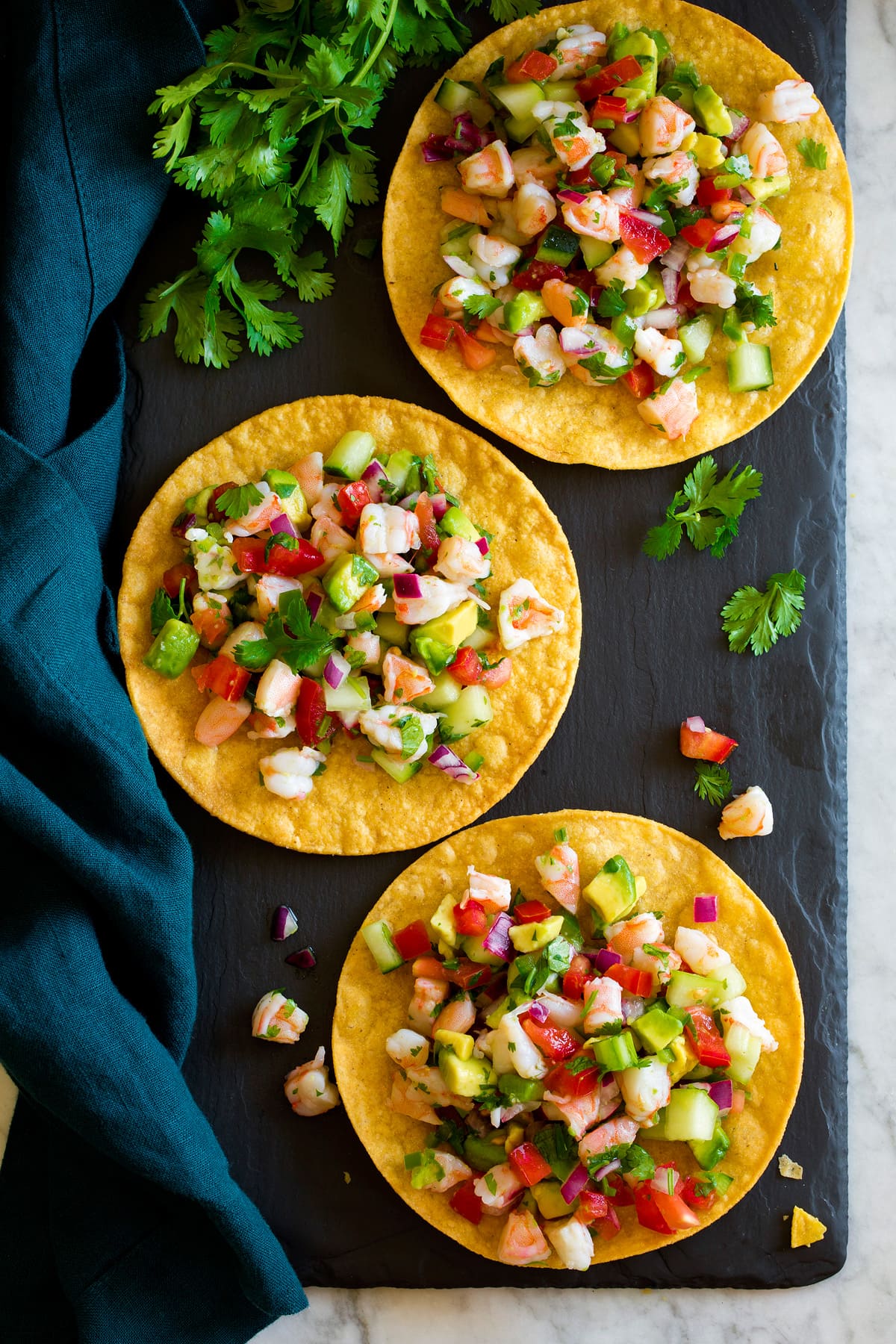 Ceviche Overhead image of ceviche served on tostada shells resting on a black slate tray.