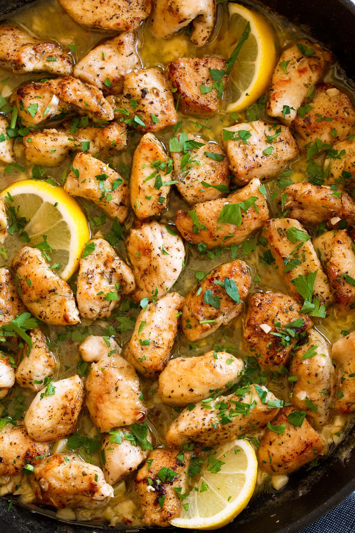 Chicken Scampi Chicken scampi shown overhead in a dark skillet.