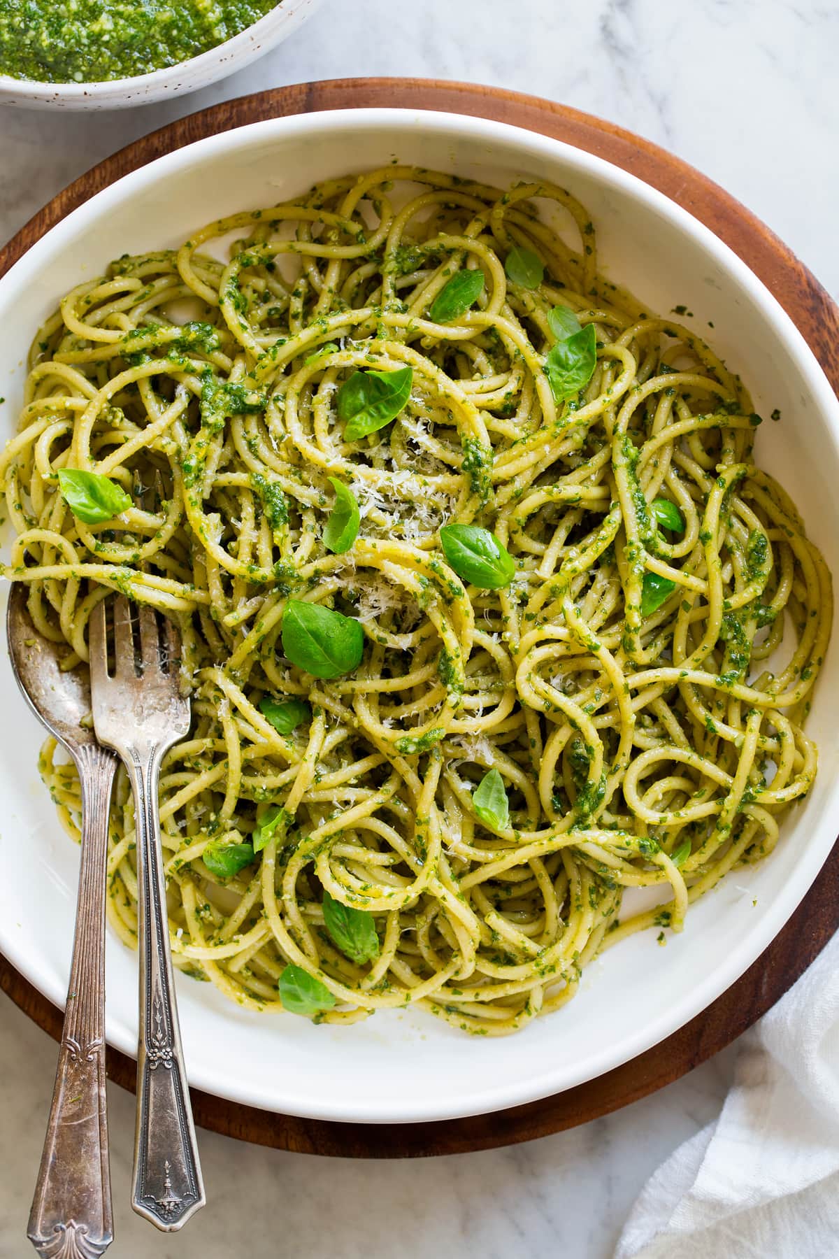Fresh Basil Pesto Recipe Image showing serving suggestion of pesto. Pesto is tossed of freshly cooked spaghetti pasta in a pasta bowl.