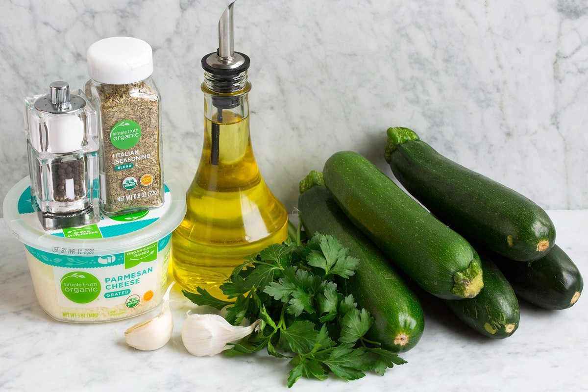 Baked Zucchini Image of ingredients used to make baked zucchini. Includes 5 medium zucchini, parsley, olive oil, Italian seasoning, salt and pepper, parmesan and garlic.