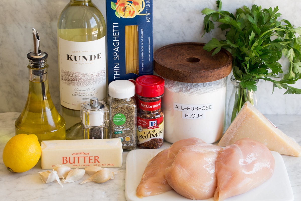 Chicken Scampi Image of ingredients used to make chicken scampi. Includes chicken breasts, olive oil, white wine, butter, garlic, lemon, pasta, Italian seasoning, red pepper flakes, salt, pepper, flour, parmesan and parsley.