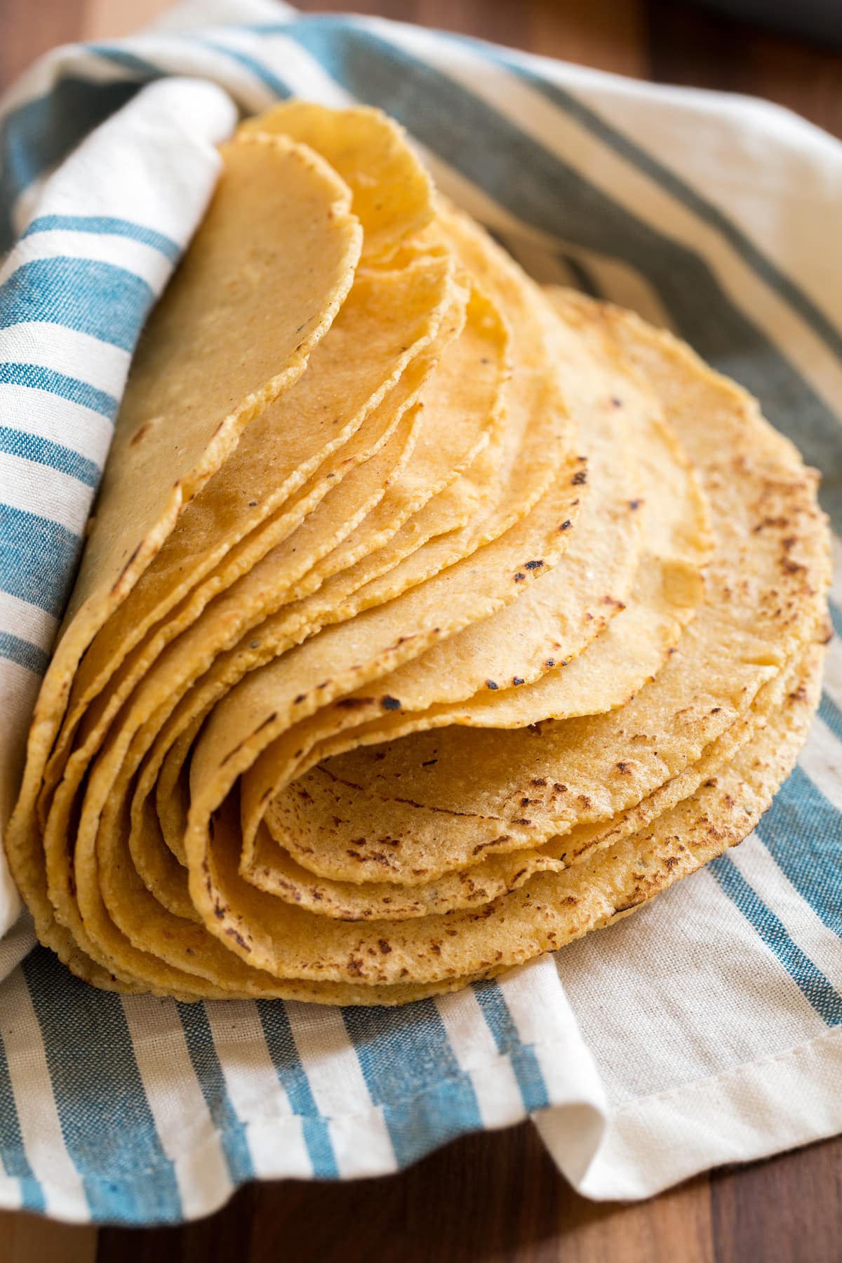 Homemade Corn Tortillas Stack of homemade yellow corn tortillas folded over to show pliability.
