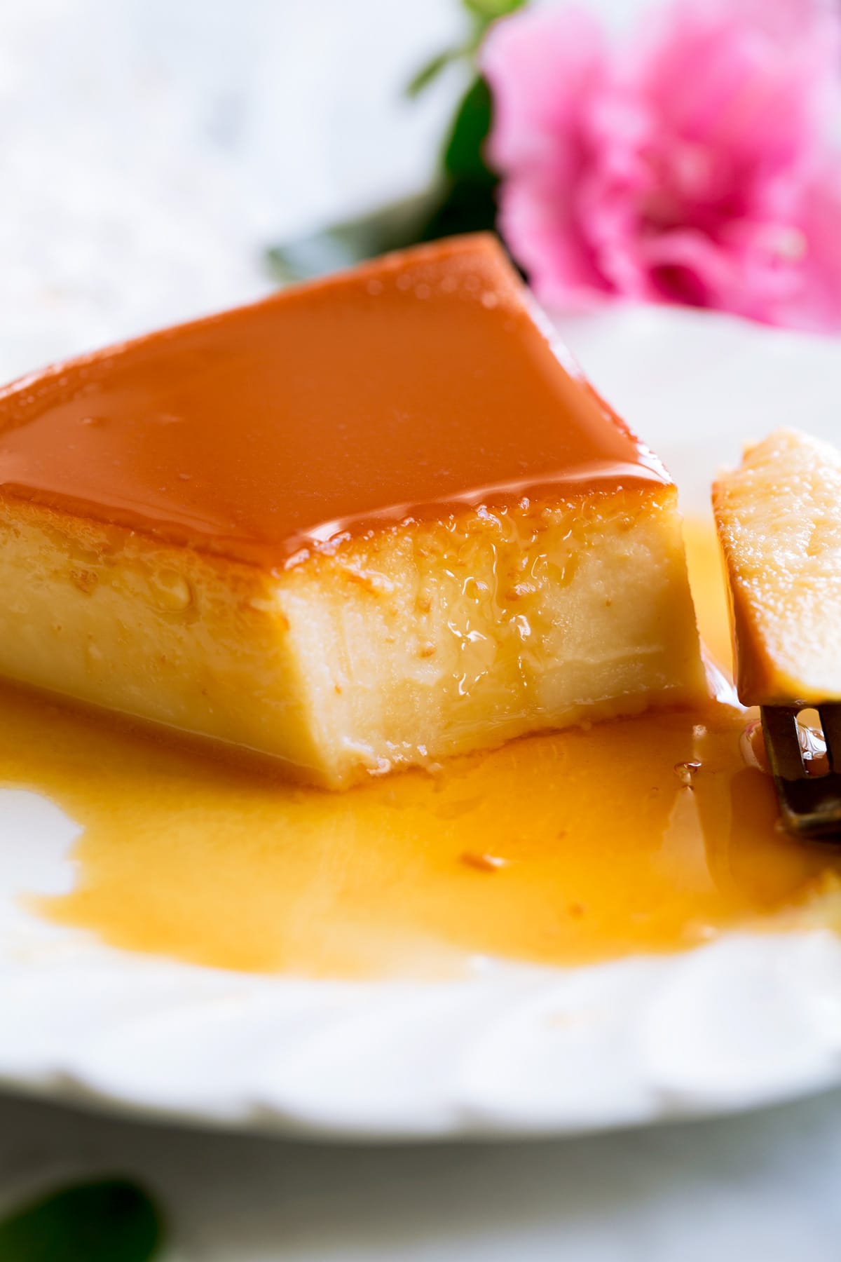 Flan Recipe Close up image of flan cut into with a fork.
