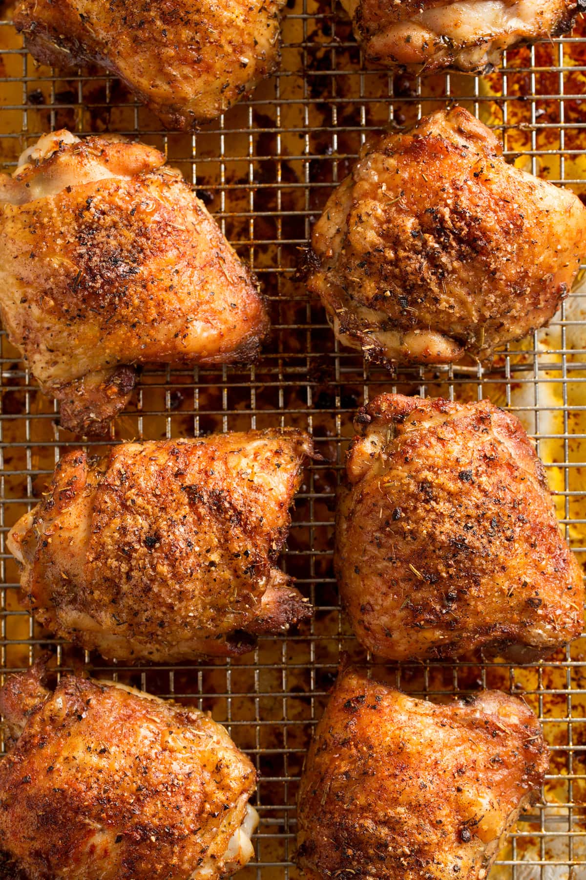 Chicken thighs on wire rack shown after baking. Chicken thighs on wire rack shown close up after baking.