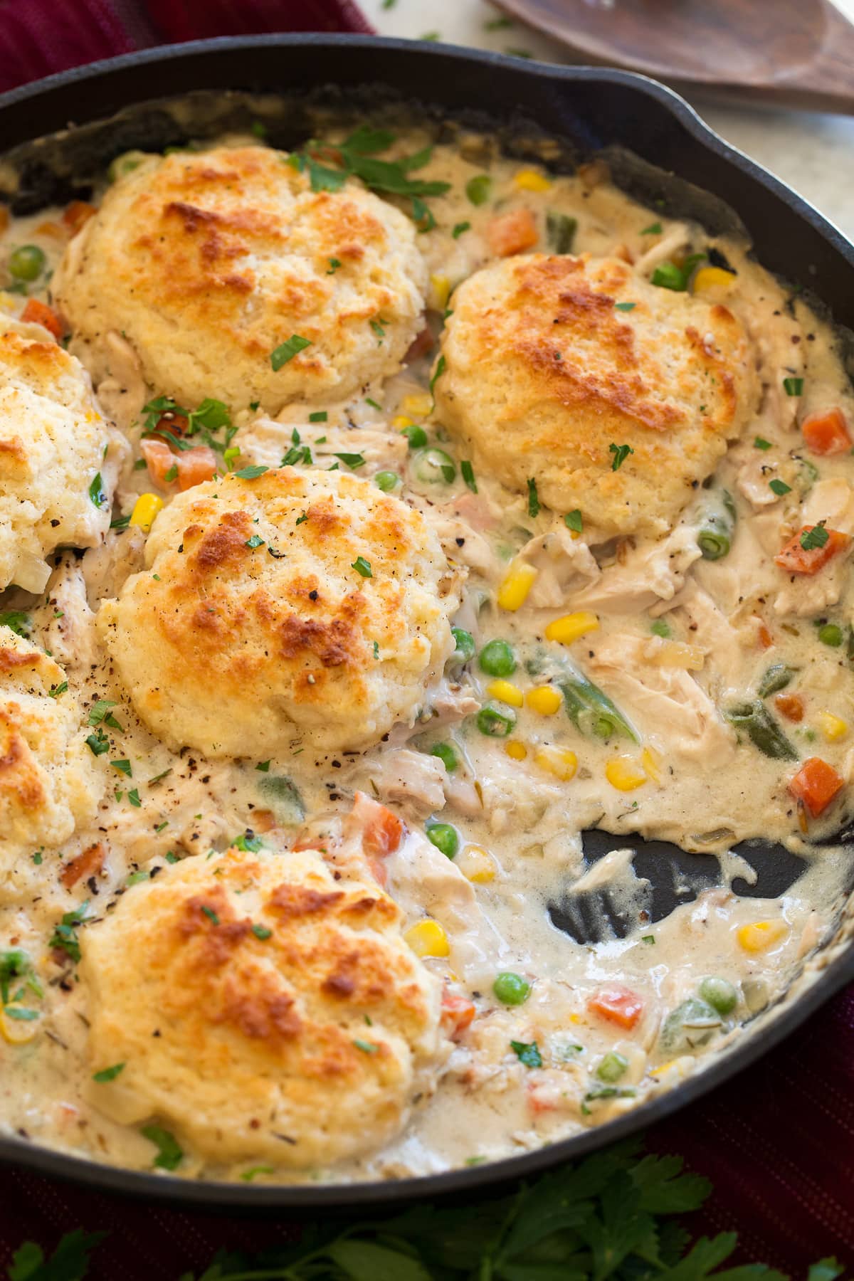 Chicken Pot Pie with Biscuits Image of Chicken Pot Pie with Biscuits shown in a cast iron skillet with a scoop removed from pot pie.
