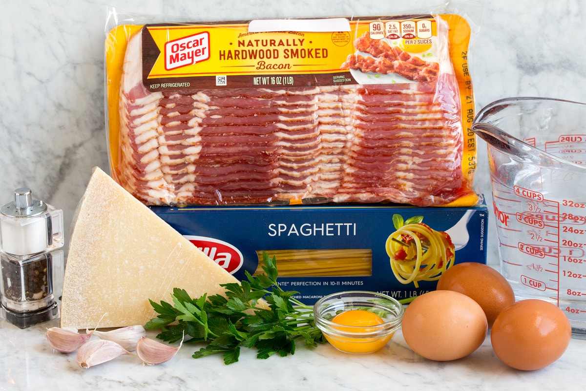 Pasta Carbonara Image of pasta carbonara ingredients. Includes spaghetti, bacon, parsley, parmesan, eggs, egg yolk, water, garlic, salt and pepper.