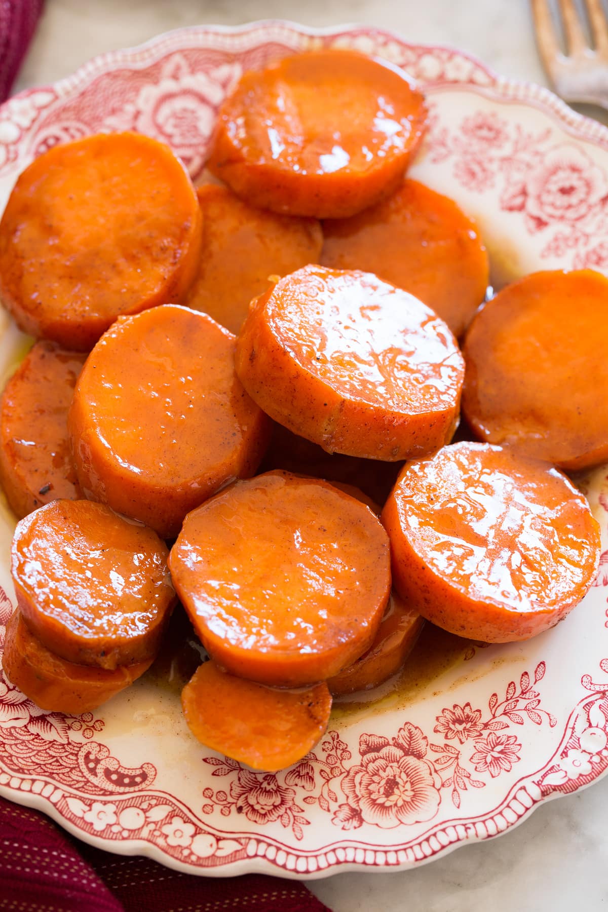 Candied Yams Close up image of candied yams on a red and white decorative side plate.
