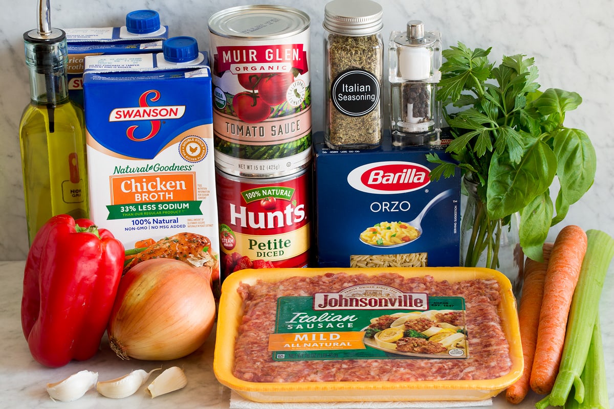 Italian Sausage Orzo Soup Image of ingredients used to make Italian sausage and orzo soup. Includes mild Italian sausage, orzo, carrots, celery, basil, parsley, Italian seasoning, salt and pepper, tomato sauce, diced tomatoes, chicken broth, yellow onion, bell pepper, olive oil and garlic.