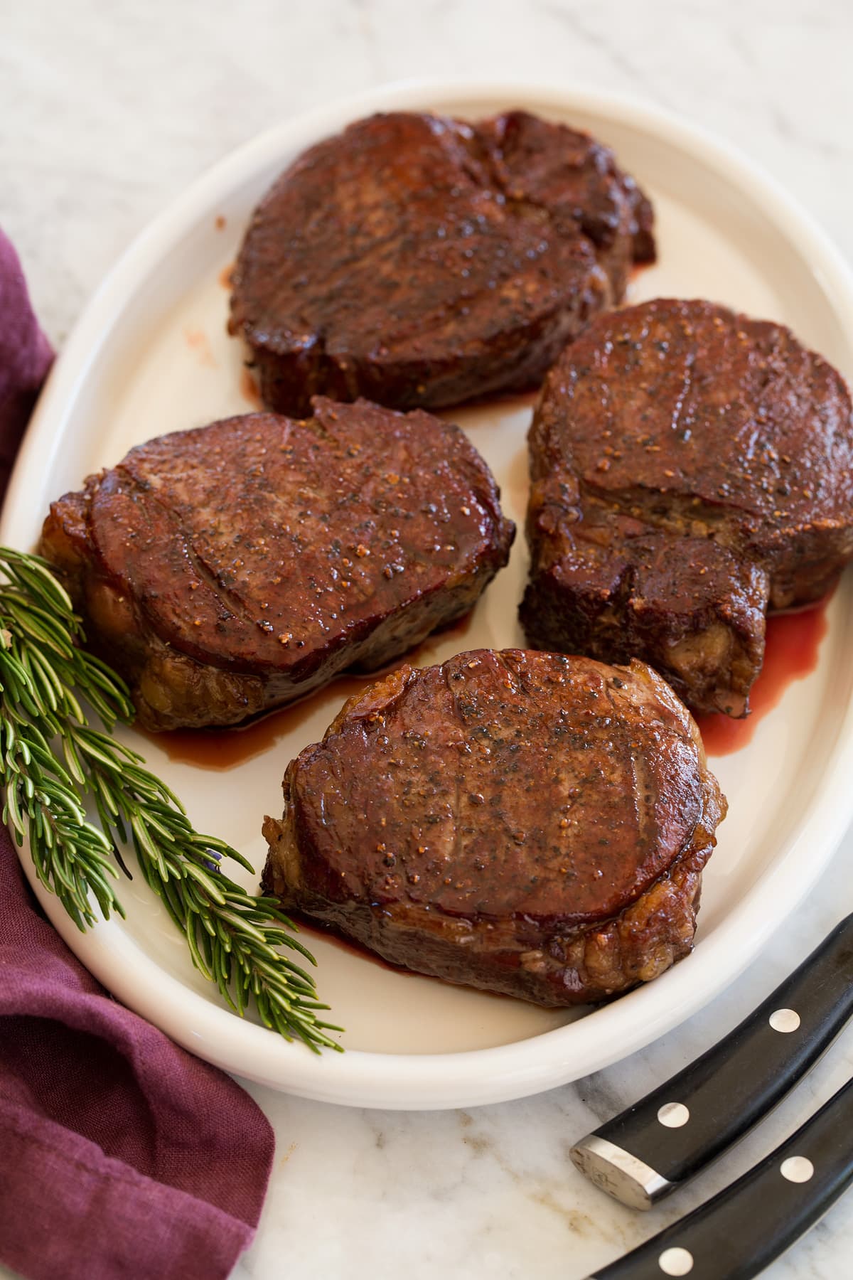 Filet Mignon Four cooked fillet mignon steaks on a serving platter.