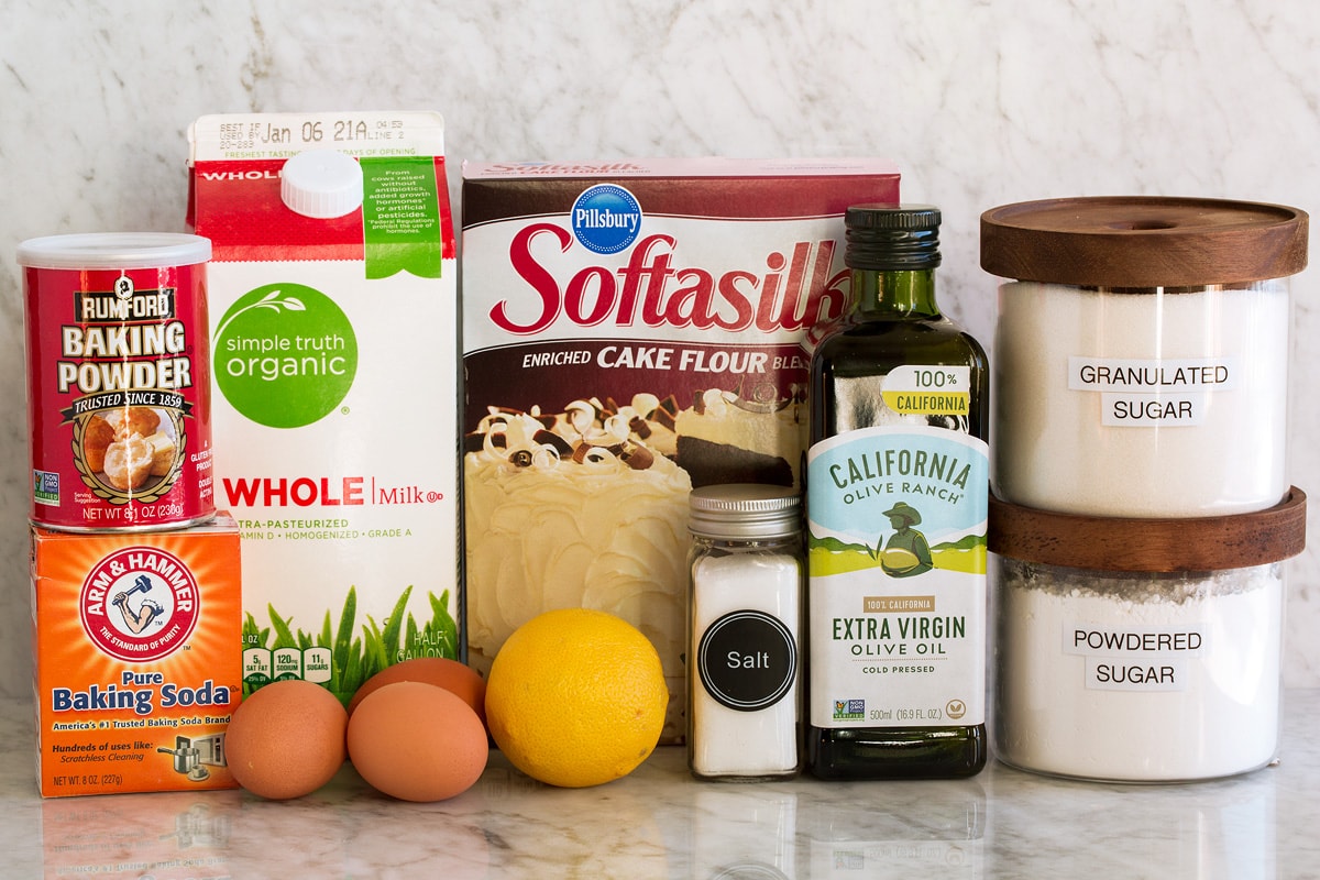 Olive Oil Cake Photo of ingredients used to make olive oil cake. Includes cake flour, baking powder, baking soda, salt, eggs, lemon, extra virgin olive oil, milk, granulated sugar and optional powder sugar.
