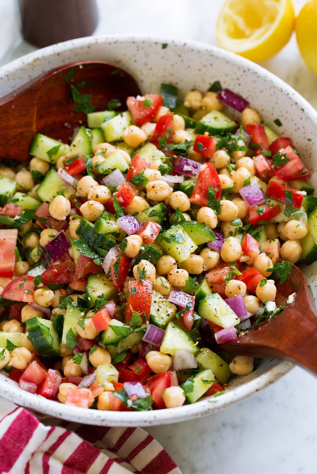 Chickpea Salad Chickpea Salad shown in a serving bowl with wooden serving spoons.