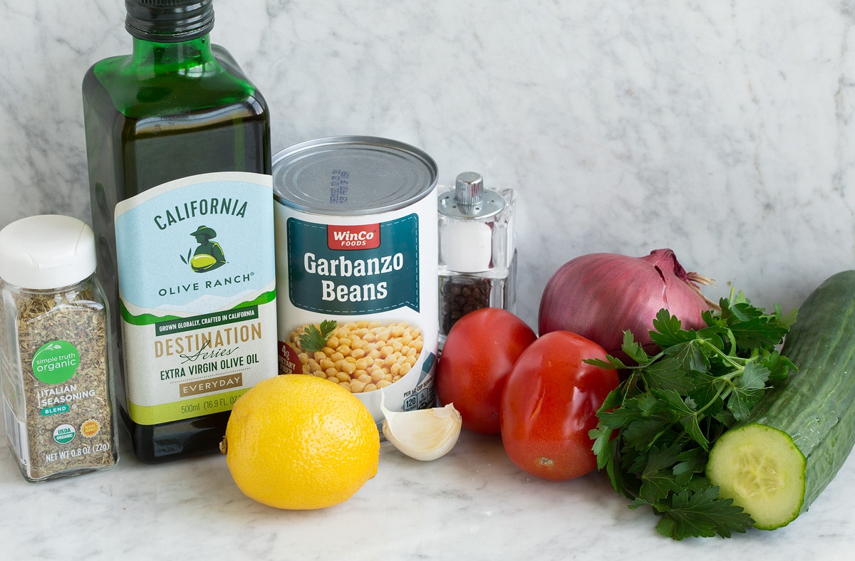 Chickpea Salad Photo of ingredients used to make chick pea salad. Includes olive oil, chickpeas/garbanzo beans, tomatoes, red onion, parsley, cucumber, garlic and lemon.
