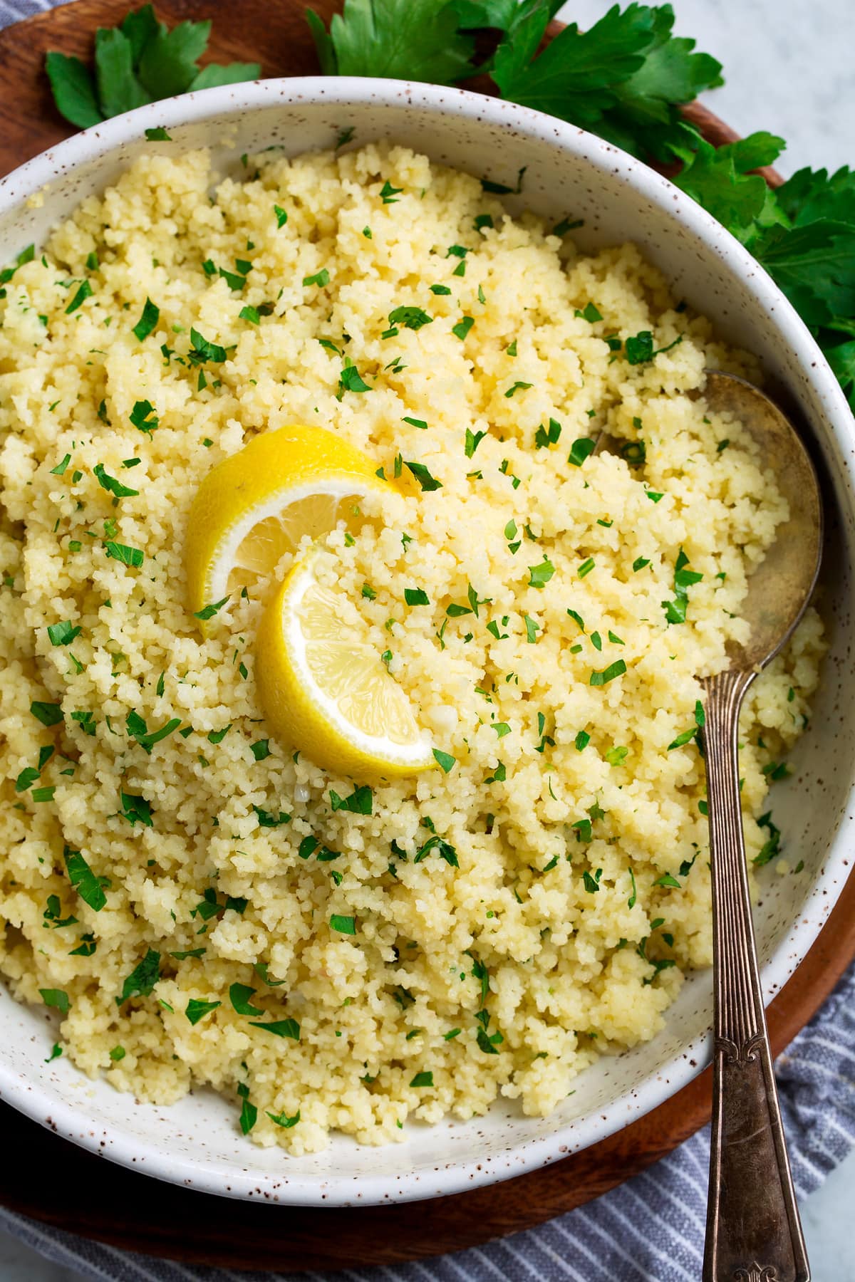 Lemon Couscous Close up overhead photo of lemon couscous garnished with parsley and lemon slices.