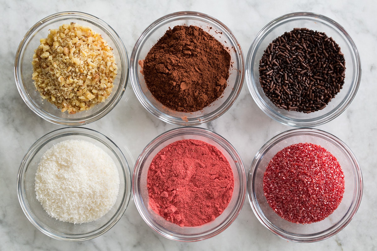 Chocolate Truffles Photo of topping ideas of chocolate truffles. Shows chopped nuts, cocoa powder, sprinkles, shredded coconut, pulverized freeze dried strawberries and colored sugar in individual small glass bowls.