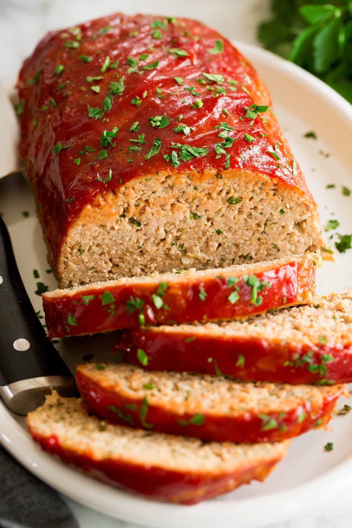 Turkey Meatloaf Close up photo of turkey meatloaf with several slices cut. Shown from a side angle.
