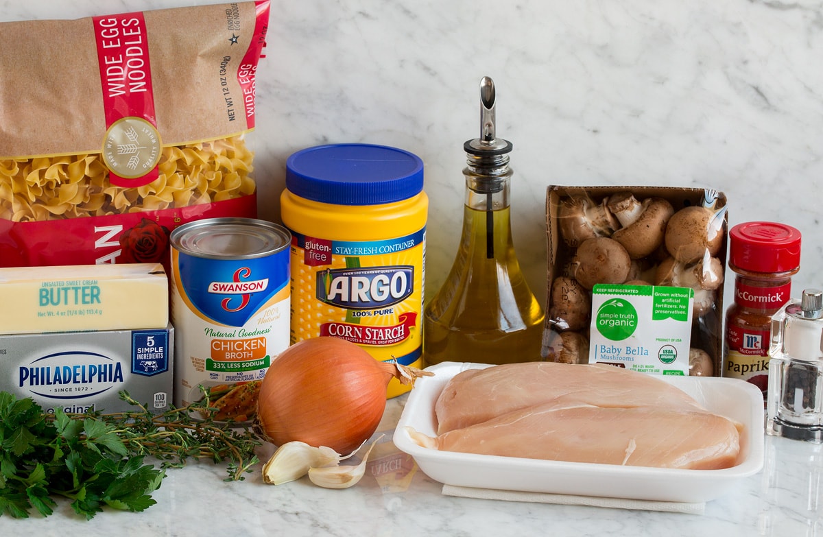 Chicken Stroganoff Photo of ingredients used to make chicken stroganoff. Includes chicken breasts, mushrooms, yellow onion, garlic, parsley, cream cheese, butter, chicken broth, thyme, egg noodles, olive oil, paprika, salt and pepper.