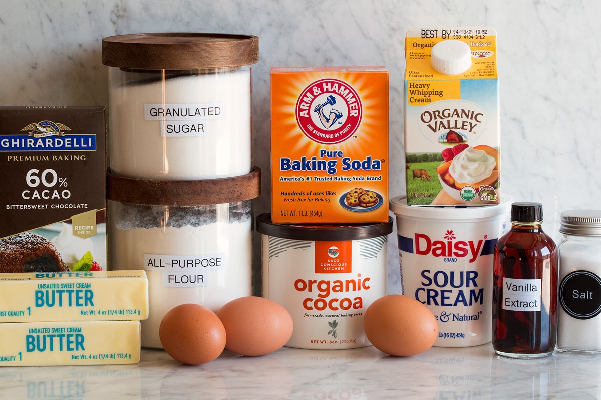 Chocolate Bundt Cake Photo of ingredients used for chocolate bundt cake. Includes flour, sugar, butter, chocolate, eggs, cocoa powder, baking soda, cream, sour cream, vanilla and salt.