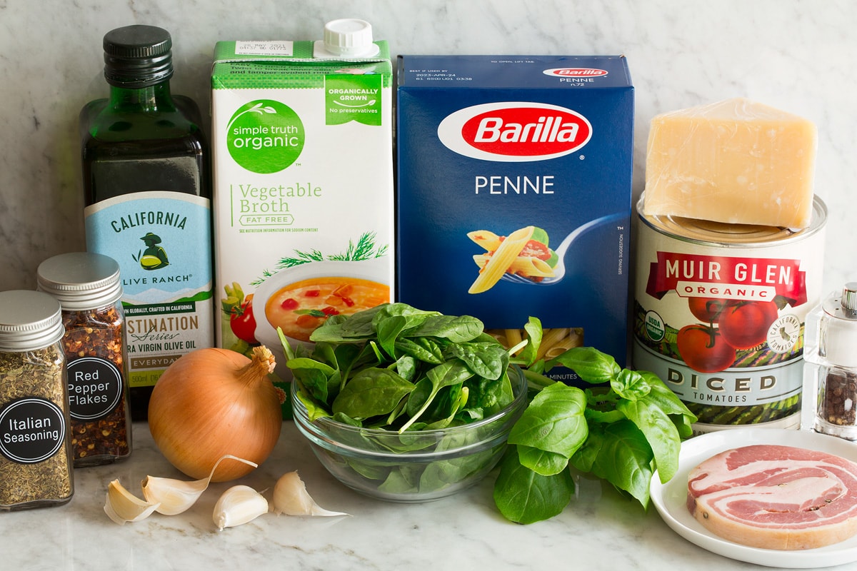 One Pot Pasta Photo of Ingredients used to make one pot pasta. Includes penne pasta, parmesan, canned tomatoes, spinach, basil, Italian seasoning, pancetta, basil, yellow onion, garlic, red pepper flakes, olive oil and vegetable broth.