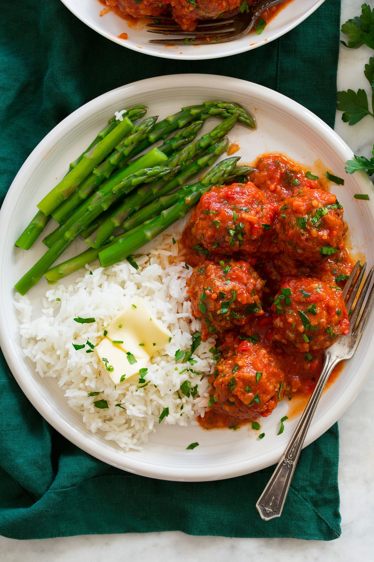 Porcupine Meatballs Overhead photo of Porcupine Meatballs meatballs on a plate with rice and asparagus.