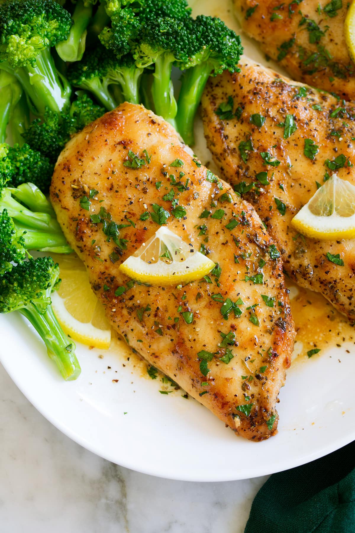 Lemon Pepper Chicken Close up photo of lemon pepper chicken shown from above on a white plate.