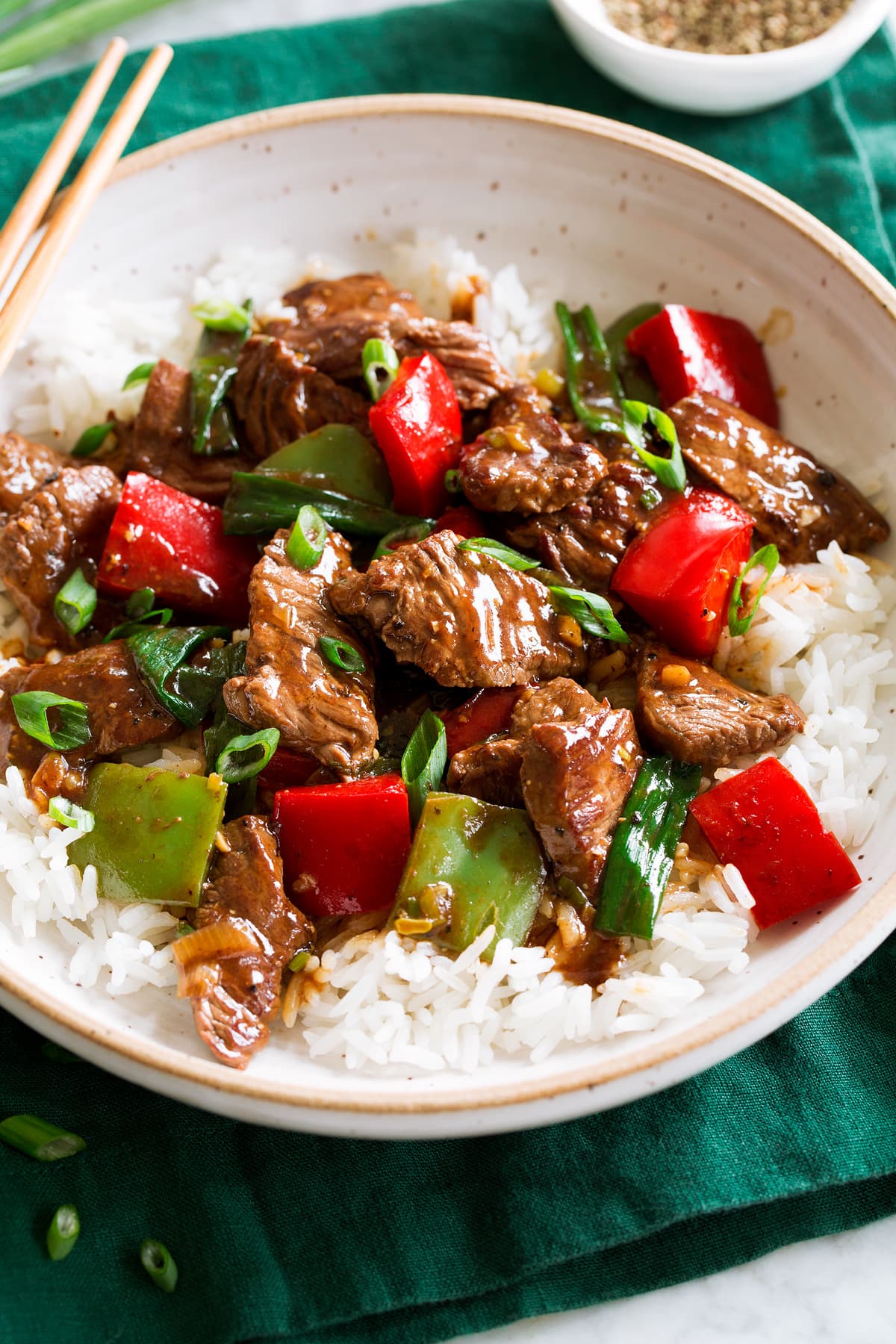 Pepper Steak Photo: Pepper Steak in a bowl over white rice. Bowl is resting on a dark green cloth over a marble surface.