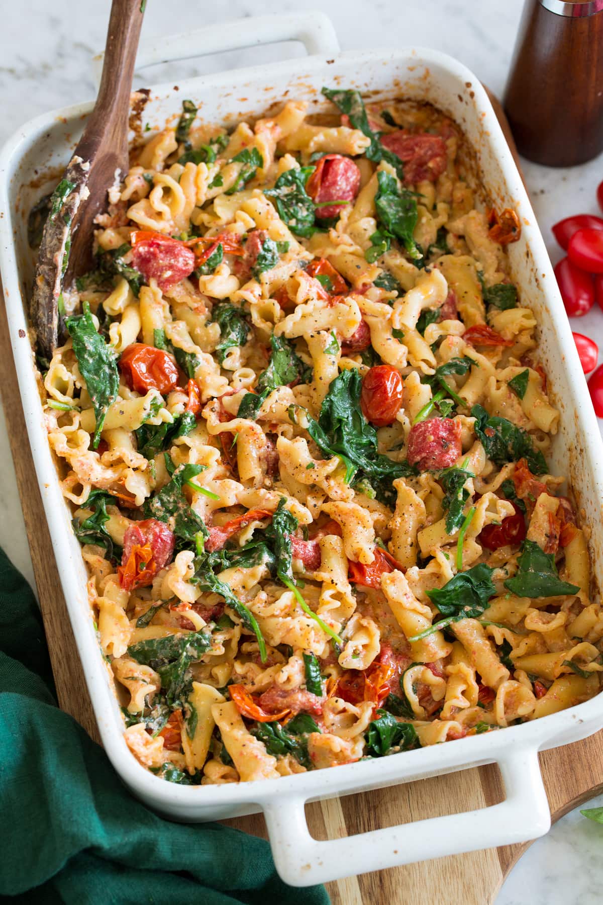 Baked Feta Pasta Photo: Baked feta pasta in a white rectangular baking dish shown from a side angle.