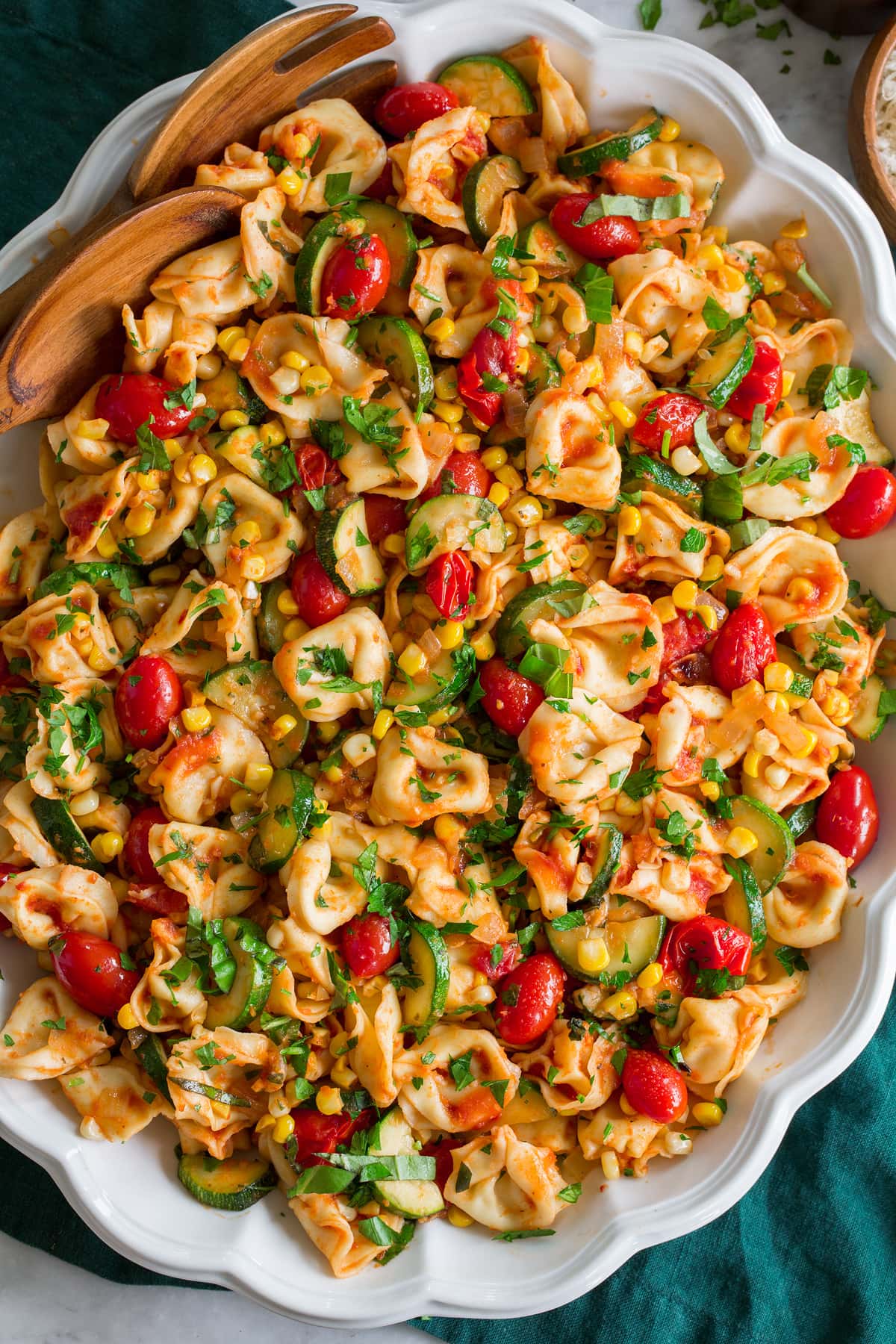 Tortellini with Summer Veggies Photo: Overhead image of cheese tortellini and sauteed vegetables shown close up in a white scalloped platter.