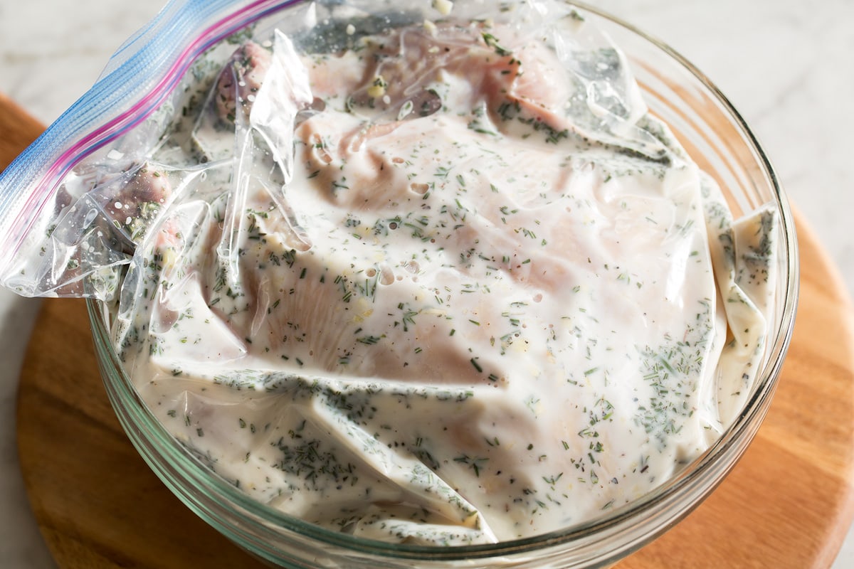 Buttermilk Roast Chicken Whole chicken shown in brine in a large bag in a bowl.