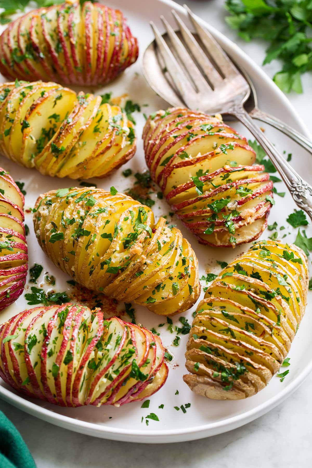 Hasselback Potatoes Hasselback Potatoes shown sliced with parmesan and parsley on top.
