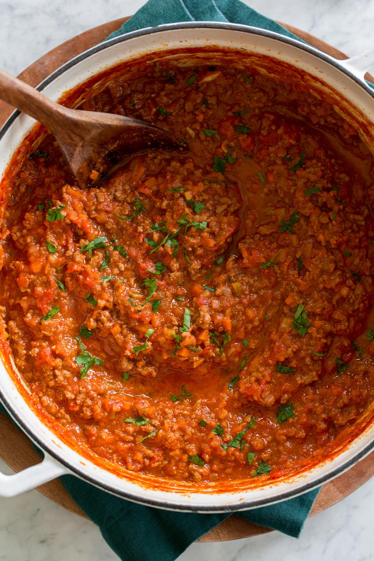 Bolognese Sauce White enameled cast iron pot with bolognese sauce shown from overhead.