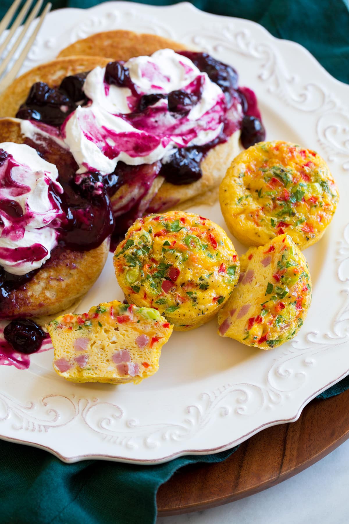 Egg Muffins Egg muffins on a plate shown with serving suggestion of pancakes with blueberry syrup.