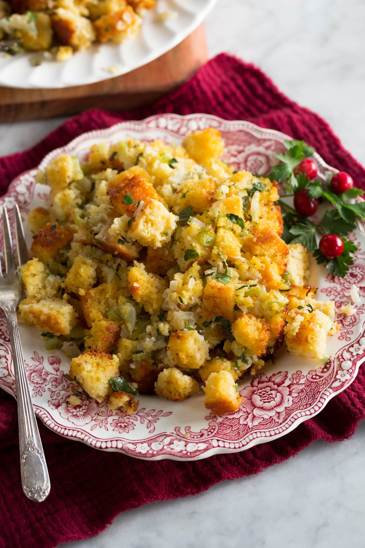 Cornbread Stuffing Single serving of cornbread stuffing on a small antique white and red serving plate.