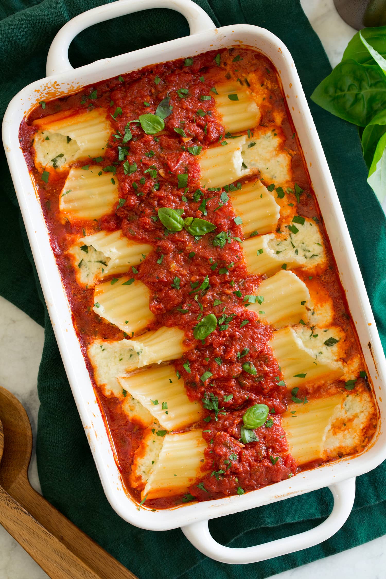 Manicotti Manicotti shown from overhead in an 11 by 7 inch white rectangular baking dish.