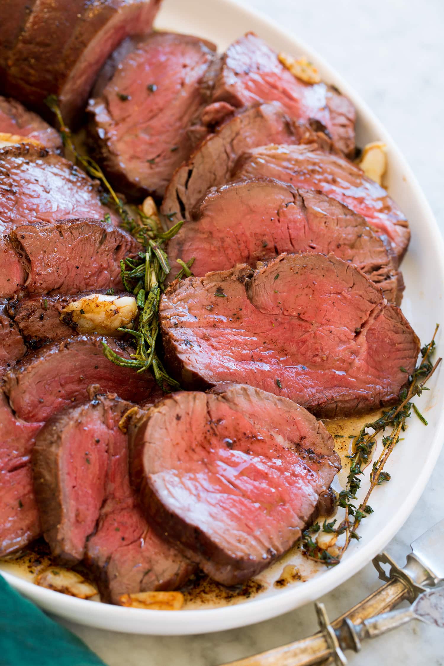 Beef Tenderloin Close up photo of beef tenderloin cut into slices on a white serving platter.